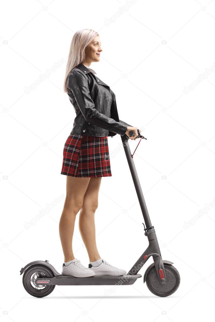 Young trendy female riding on an electric scooter isolated on white background
