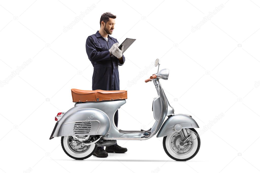Motorbike mechanic in a uniform inspecting a scooter and writing a document isolated on white background