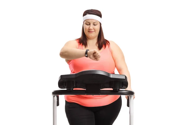 オーバーウエイト女性オンA Treadmillチェック彼女のフィットネスバンド絶縁上の白い背景 — ストック写真