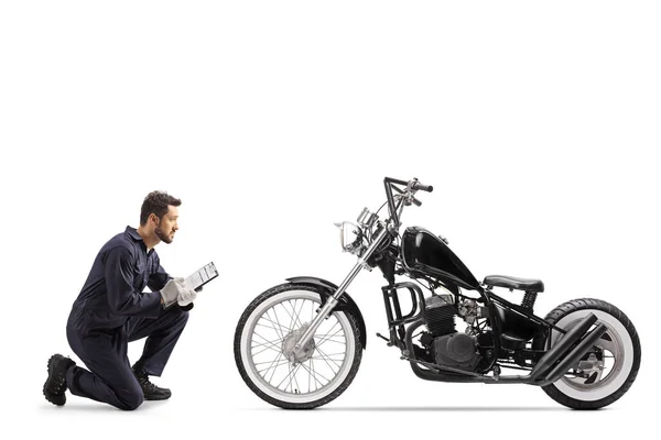 Motorbike Mechanic Uniform Kneeling Looking Chopper Writing Document Isolated White — Stock Photo, Image