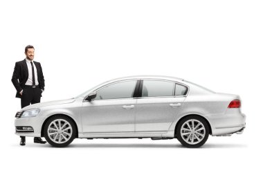 Beyaz arka planda izole edilmiş gümüş renkli yeni bir arabayı ayakta ve zincirleyen bir iş adamı.