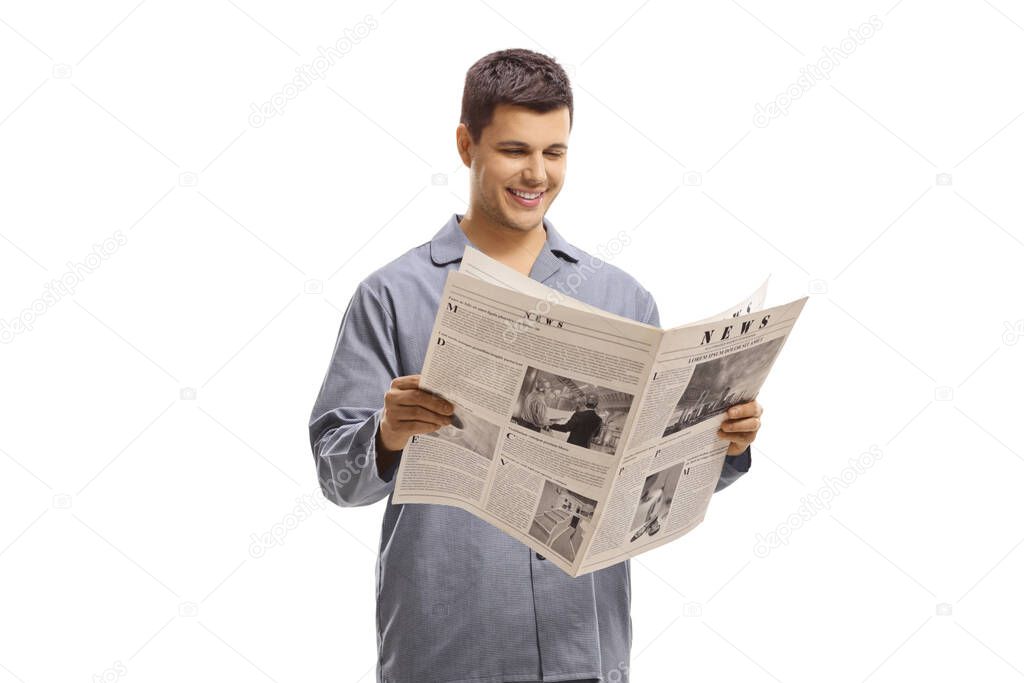 Man in pyjamas standing and reading a newspaper isolated on white background