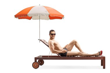 Beyaz arka planda şemsiye altında güneşlenen çekici adam.