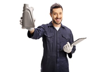 Otomobil tamircisi önünde bir şişe motor yağı tutuyor ve beyaz arka planda izole edilmiş kameraya bakıyor.