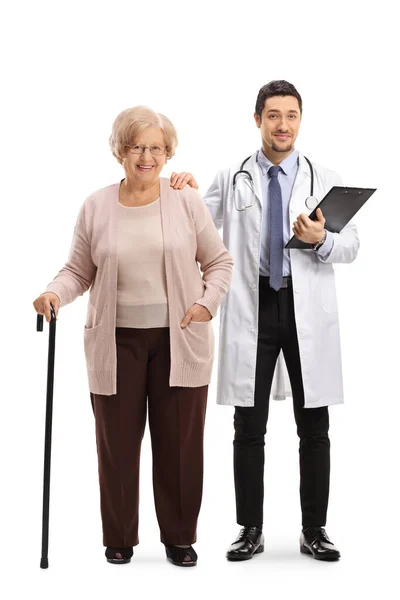医師と歩行杖を持つ高齢女性の完全な長さの肖像画は 白い背景に隔離されたポーズ — ストック写真