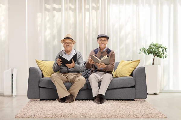 Dois Idosos Sentados Sofá Lendo Livros Uma Sala Estar — Fotografia de Stock