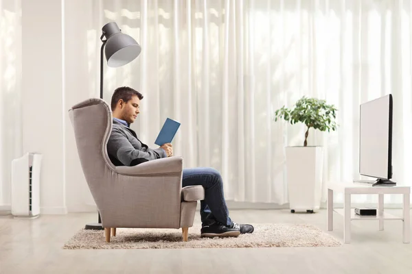 Young Man Home Sitting Armchair Reading Boo — Stock Photo, Image