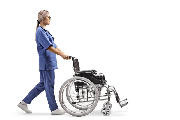 Vollständige Profilaufnahme Einer Jungen Krankenschwester Die Einen Leeren Rollstuhl Isoliert — Stockfoto