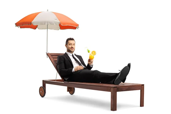 Muž Černém Obleku Ležící Soláriu Deštníkem Pití Koktejl Izolovaný Bílém — Stock fotografie