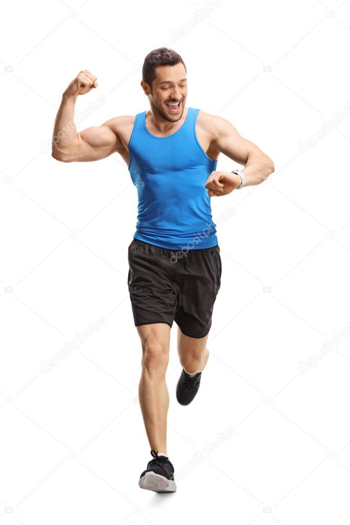 Full length portrait of a male athlete running towards the camera and checking time on smartwatch isolated on white background