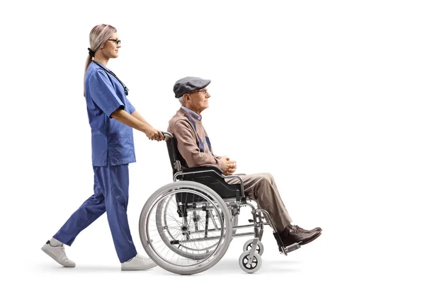 白地に隔離された車椅子で老人を押す看護婦の全長プロフィール — ストック写真