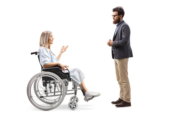 白い背景に隔離された髭の男と話す車椅子の女性患者の完全な長さのプロフィールショット — ストック写真