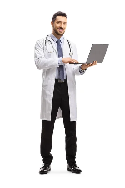 男性医師立って 白い背景に隔離されたラップトップコンピュータを使用しての完全な長さの肖像画 — ストック写真