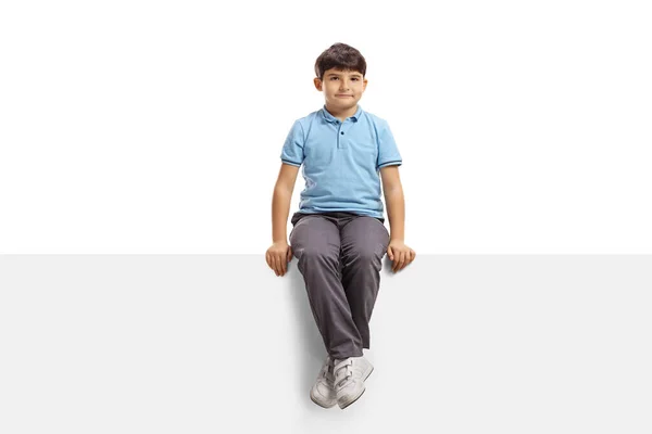 男孩坐在一块被白色背景隔开的空白标牌上 — 图库照片