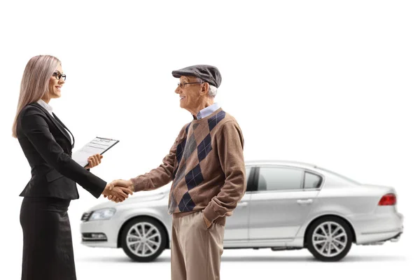 白地に隔離された車の前で年配の紳士と握手するビジネスマン女性 — ストック写真