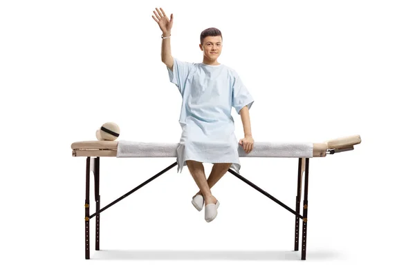 Young Male Patient Hospital Gown Sitting Medical Bed Waving Isolated — Stock Photo, Image