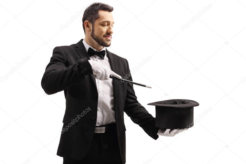 Magician performing a trick with a magic wand and a top hat isolated on white background
