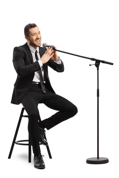 Cantor Masculino Terno Sentado Uma Cadeira Cantando Microfone Isolado Fundo — Fotografia de Stock