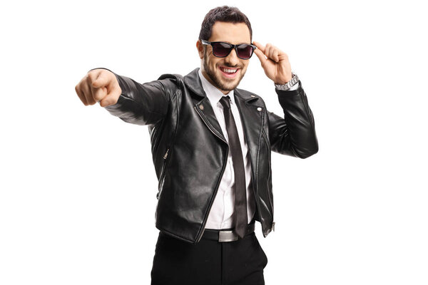 Guy in a black leather jacket pointing towards camera isolated on white background