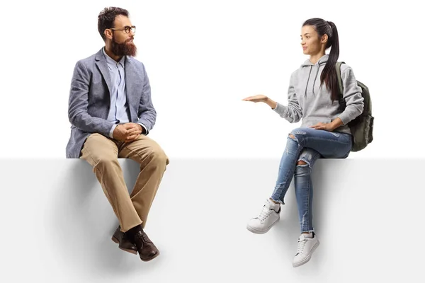 Female student sitting on a panel gesturing with hand and talking to a bearded man isolated on white background