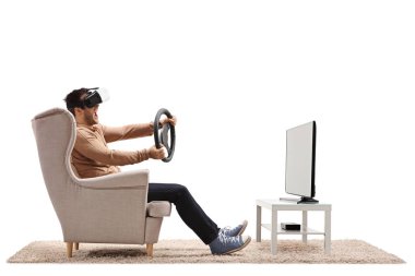 Sanal gerçeklik kulaklığı takan ve beyaz arka planda izole edilmiş bir televizyonun önünde direksiyon tutan bir adam.