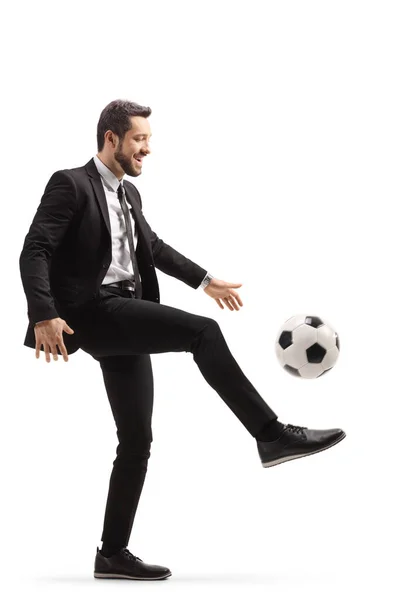 白地に隔離されたサッカーボールで遊んでいるビジネスマンの完全な長さのプロフィールショット — ストック写真