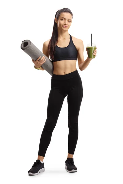 一个身穿运动服的女孩拿着一个运动垫和一个白色背景的绿色滑雪板的全长肖像 — 图库照片