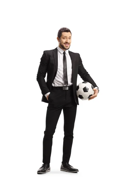 白い背景に孤立したサッカーを保持黒のスーツの男の完全な長さの肖像画 — ストック写真