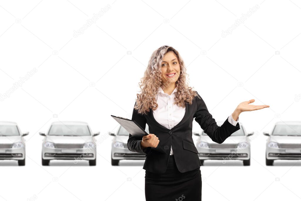 Female host in a car showroom gesturing welcome isolated on white background