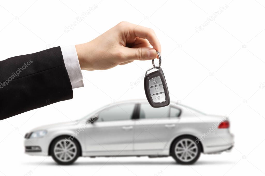 Male hand holding car keys from a silver car isolated on white background