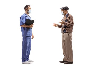 Maskeli bir sağlık çalışanının beyaz arka planda izole edilmiş yaşlı bir adamla konuşurken tam boy profil fotoğrafı.