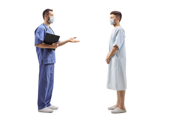一名戴口罩的医护人员与一名因白人背景隔离而住在医院的年轻病人交谈时的全景照片 — 图库照片