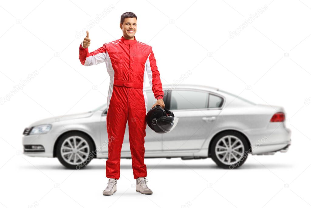 Full length portrait of a car racer in front of a silver car showing thumbs up isolated on white background