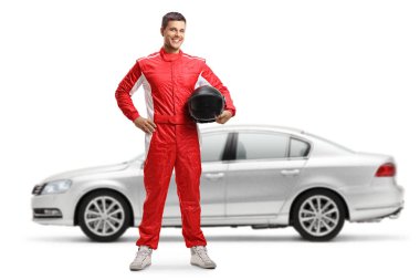 Beyaz arka planda izole edilmiş gümüş bir arabanın önünde duran ve kask tutan bir yarışçının tam boy portresi.