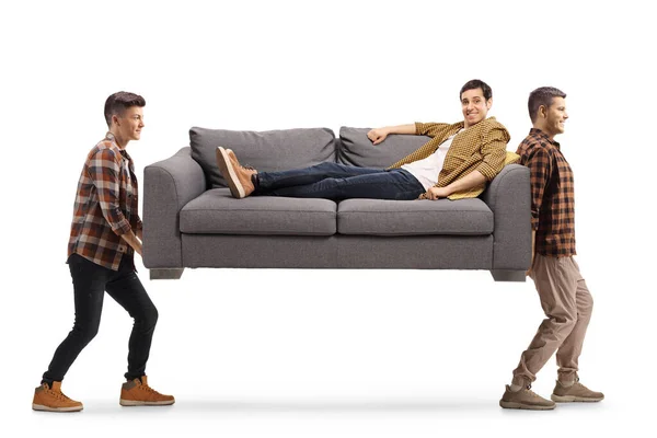 Anak Muda Membawa Sofa Dengan Seorang Pria Berbaring Dan Tersenyum — Stok Foto