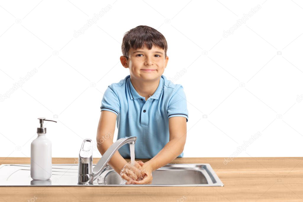 Child washing hands in a sink and looking at the camera isolated on white background