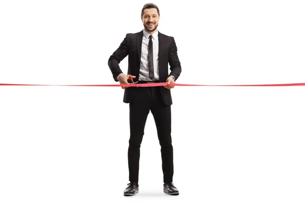Full Length Portrait Businessman Cutting Red Ribbon Tape Looking Camera — Stock Photo, Image