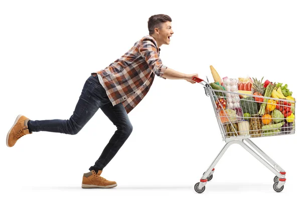 Gelukkige Jongeman Loopt Met Een Volle Winkelwagen Geïsoleerd Witte Achtergrond — Stockfoto