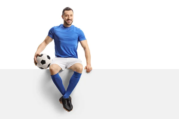 Footballer Blue Jersey Soccer Ball Sitting Blank Panel Smiling Isolated — Stock Photo, Image