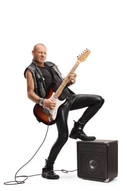 Bir rock yıldızının bacağı beyaz arka planda izole edilmiş bir amplifikatörle gitar çalarken tam boy çekimi.