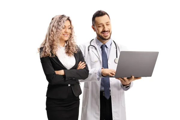 一位女商人和一位男医生正在看一台白色背景的笔记本电脑 — 图库照片