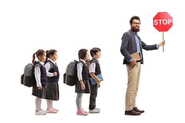 Manlig Lärare Bär Stoppskylt Med Grupp Skolbarn Uniformer Isolerade Vit — Stockfoto