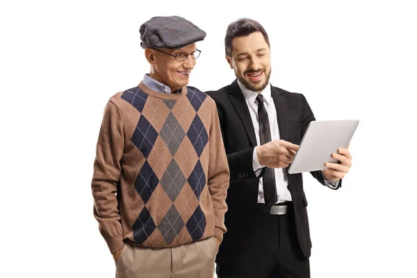白い背景に隔離された老人にタブレットを示す黒いスーツのプロの男 — ストック写真