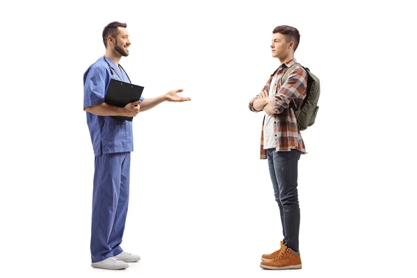 男性医療従事者と話している男性の十代の学生の完全な長さのプロフィールショット白地に隔離された — ストック写真