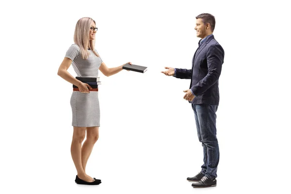 Full Length Profile Shot Young Woman Giving Book Young Man — Stock Photo, Image