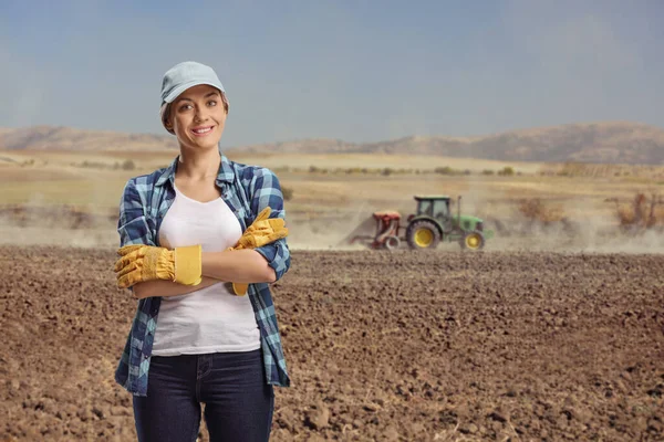 後ろにトラクターのある畑で働く女性 — ストック写真