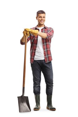 Beyaz arka planda izole edilmiş bir kürekle duran erkek bahçıvanın tam boy portresi.