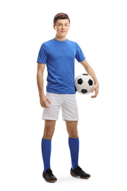 Kolunun altında top olan genç bir futbolcunun beyaz arka planda izole edilmiş tam boy portresi.