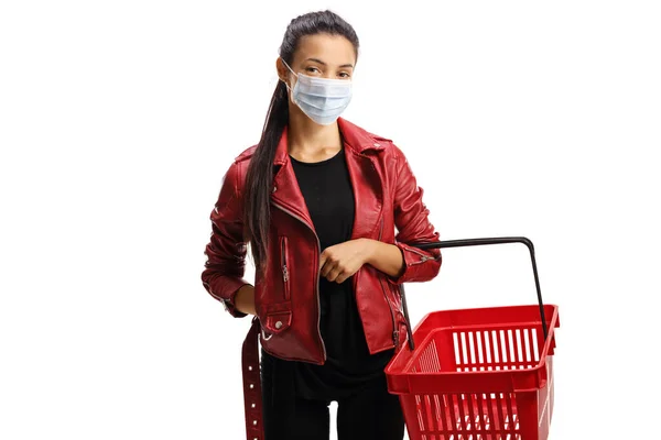 白い背景に隔離された保護顔マスクを身に着けているショッピングバスケット付きの革のジャケットの若い女性 — ストック写真