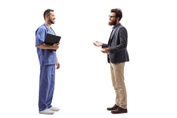 大胡子男子与身穿蓝色制服 背景为白色的男医生交谈时的全景照片 — 图库照片